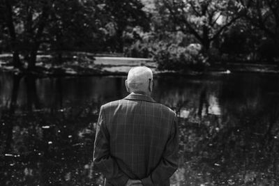 Rear view of man overlooking lake