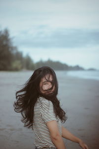 Portrait of smiling woman standing against sea