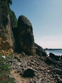 Low angle view of rock formation on beach against sky