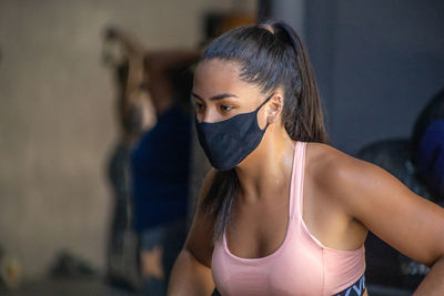 Beautiful young woman looking away with mask