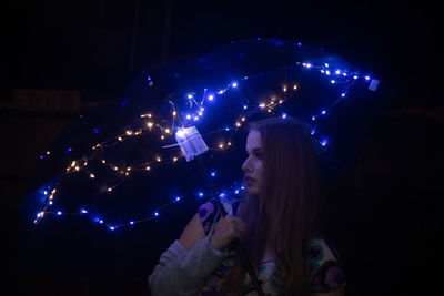High angle view of woman looking at illuminated lights at night