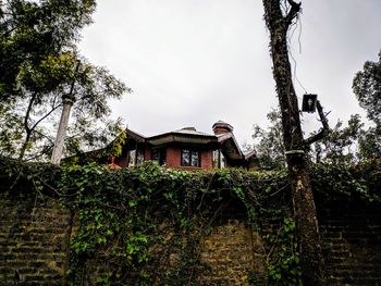 Low angle view of building and trees against sky