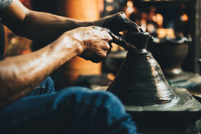 Midsection of man making pot