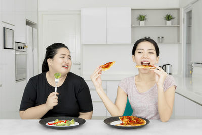 Friends having food while making face at home