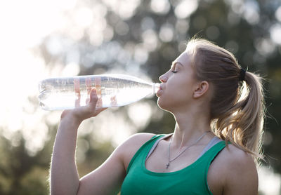 Young woman drinking water from bottle