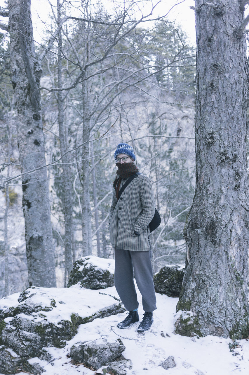 cold temperature, winter, tree, warm clothing, forest, snow, hiking, knit hat, leisure activity, full length, nature, men, one person, people, tree trunk, outdoors, adult, young adult, beauty in nature, adults only, day, one man only