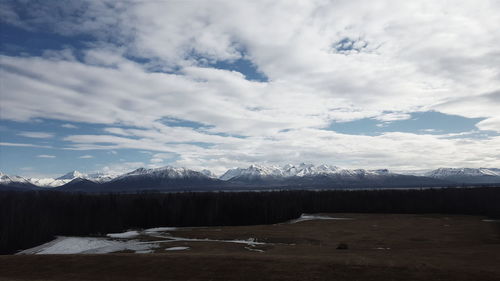 Scenic view of mountains against cloudy sky