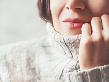 Portrait of woman snuggling in warm grey sweater. casual outfit for cold weather at winter season.