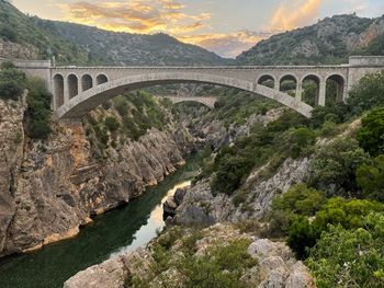 Arch bridge over river against sky
