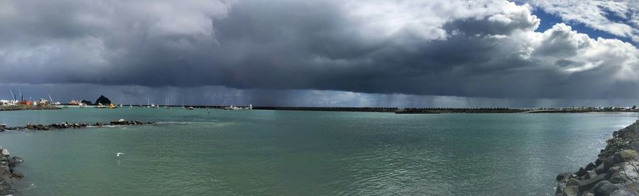 Scenic view of sea against storm clouds