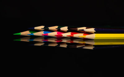 Close-up of multi colored pencils against black background