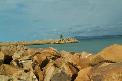 Scenic view of rocky beach against sky