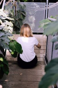 Rear view of woman sitting on steps