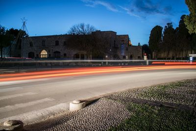 Light trails on road against sky