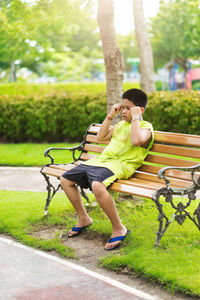 Side view of woman sitting on grass