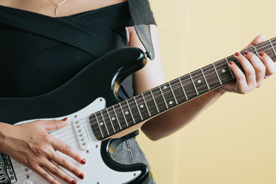 Midsection of man playing guitar