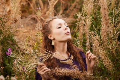 Young woman amidst plants on field