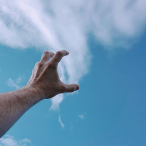 Low angle view of hand against sky
