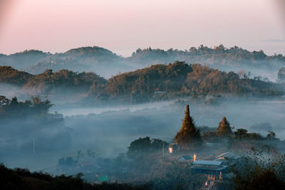Panoramic view of trees and mountains against sky during sunset
