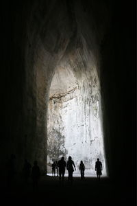 Silhouette people walking in cave
