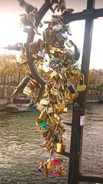 Close-up of padlocks on railing by river