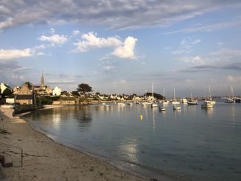 Sailboats in sea against buildings in city