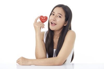 Portrait of a smiling young woman against white background