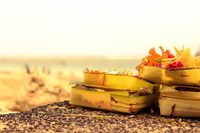 Close-up of religious offerings in basket on rock