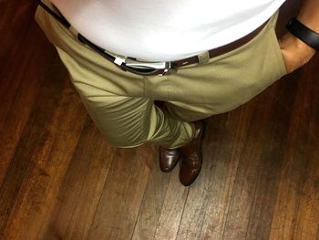 Low section of man standing on hardwood floor