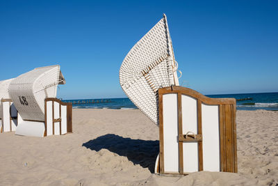 Hooded beach chair at beach against sky