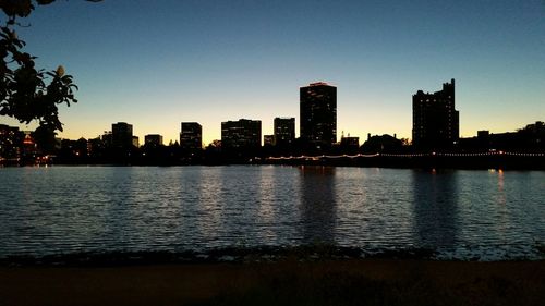 Illuminated cityscape against sky at sunset