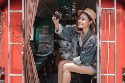 Woman sitting in a smiling while holding umbrella