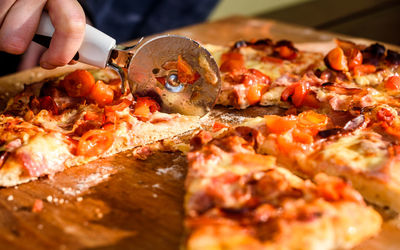 Close-up of hand holding pizza