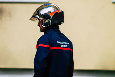 Rear view of man standing against wall