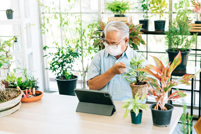 Close-up of senior man wearing mask sitting at botany