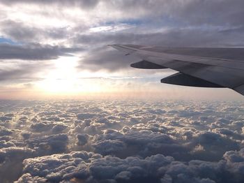 Cropped image of airplane flying over cloudscape