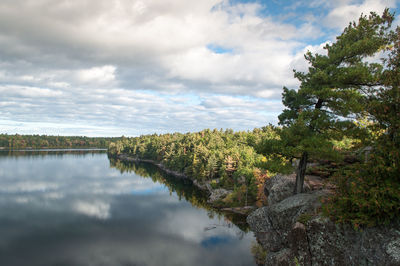 View of calm lake against cloudy sky