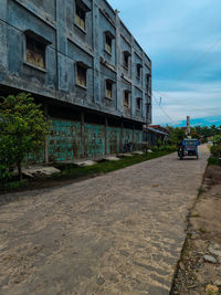 Road by building against sky in city