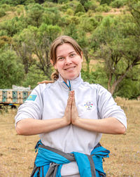 Portrait of young woman standing on field