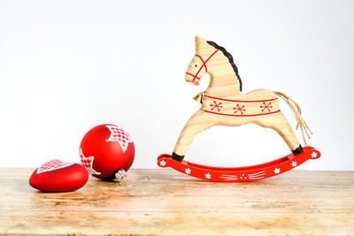 Close-up of red decoration on table against white background