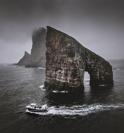 Scenic view of rock formation in sea against sky