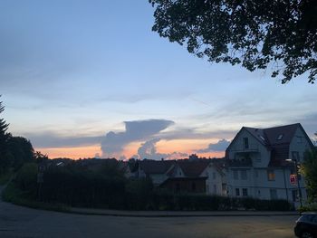 Houses and buildings against sky during sunset