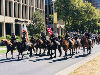 People riding horses in city