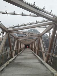 Footbridge over footpath against sky