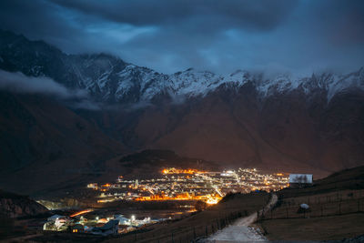 Aerial view of illuminated snowcapped mountains against sky at night