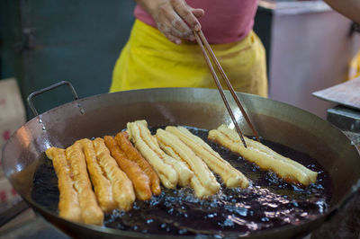 Midsection of man preparing food in cooking utensil