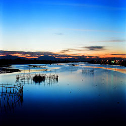 Scenic view of lake against sky during sunset