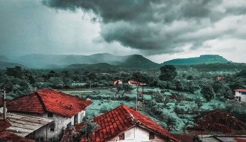 Houses on mountain against sky