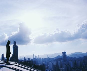 Skyscrapers in city against cloudy sky