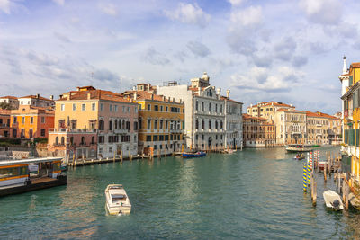 Boats in canal by buildings in city